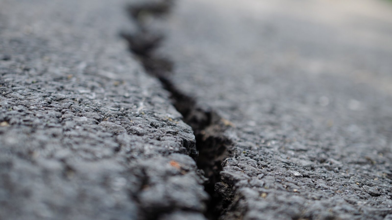 Close-up of asphalt crack repair, crack filling prevents water infiltration and costly deterioration